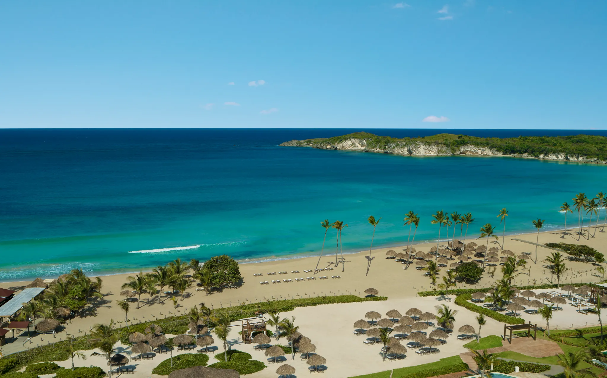 Panoramic Caribbean beach with turquoise waters and palm-lined shores at Dreams Macao Beach Punta Cana.