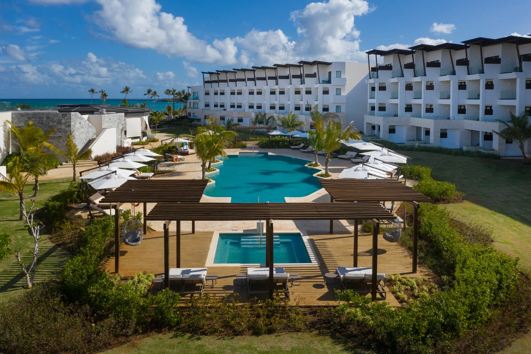 Elegant saltwater pool surrounded by modern suites and tropical landscaping at Dreams Macao Beach Punta Cana Resort.