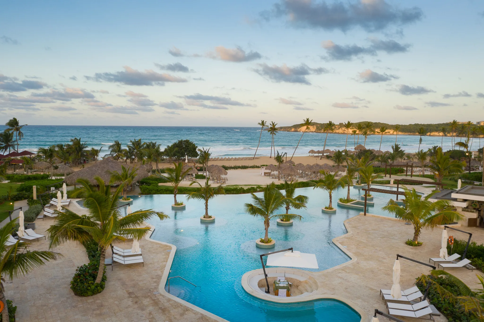 Infinity pool overlooking the Caribbean Sea at sunset at Dreams Macao Beach Punta Cana Resort.