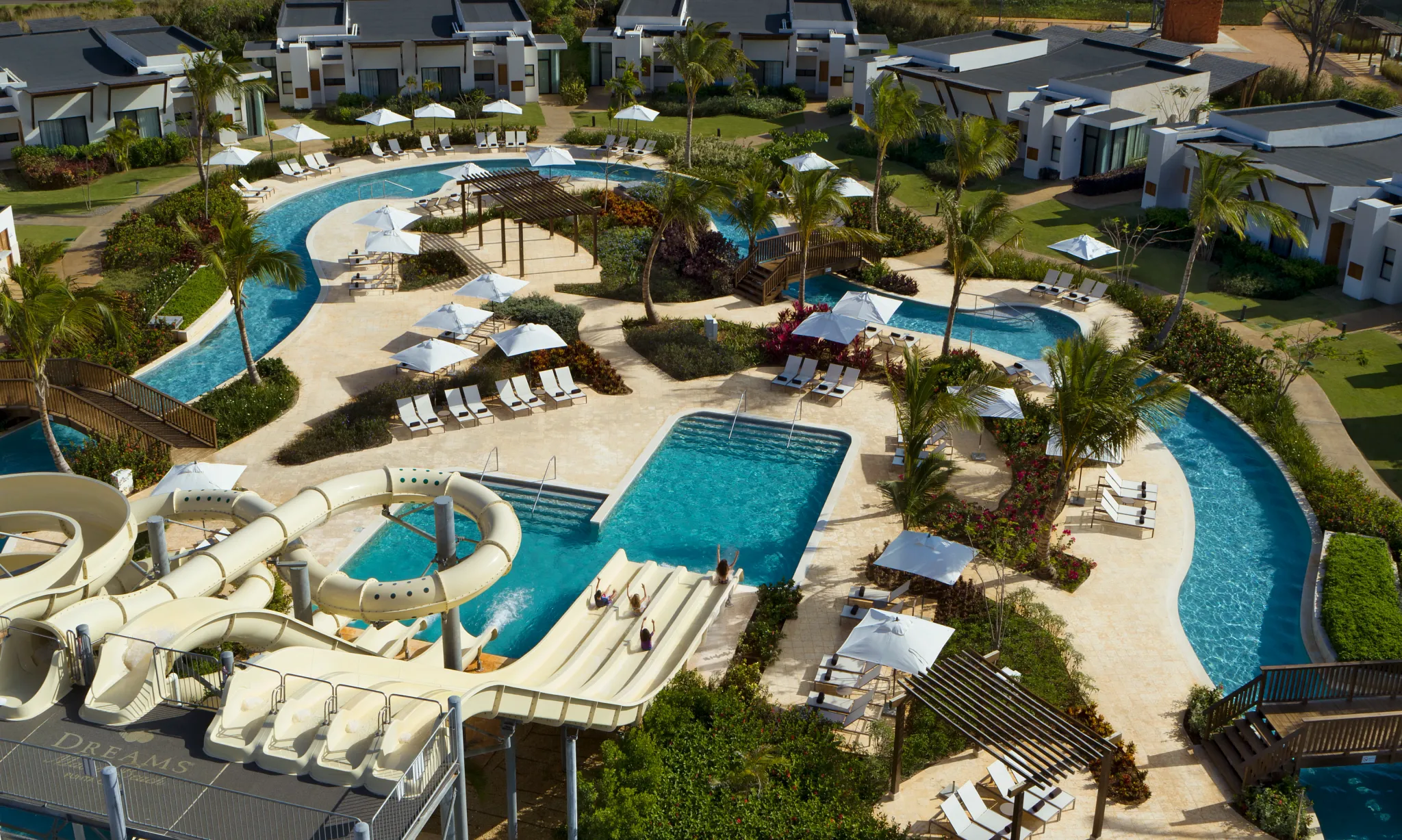 Panoramic aerial view of water slides, pools, and tropical landscaping at Dreams Macao Beach Punta Cana.